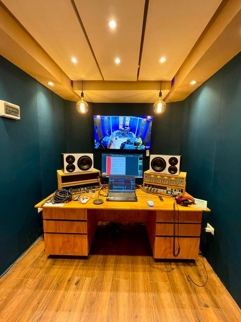 Sala de control del estudio con monitores, consola y tratamiento acústico
